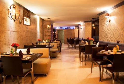 a dining room with tables and chairs in a restaurant at Plaza Gallery Hotel Boutique in San Cristóbal de Las Casas