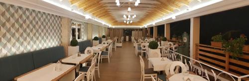 uma sala de jantar com mesas e cadeiras num restaurante em Pensiunea Edy Turda em Turda