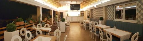 um restaurante com mesas e cadeiras num quarto em Pensiunea Edy Turda em Turda
