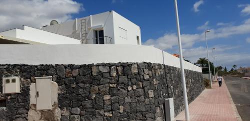 a stone retaining wall next to a building at Petit Paradis - A little bit of heaven in Callao Salvaje