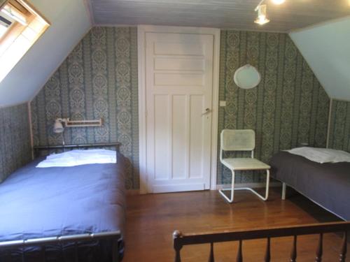 - une chambre avec un lit, une chaise et une porte dans l'établissement Corail, à Queyssac