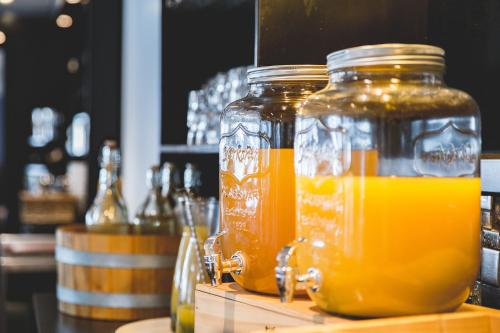 dos jarras de jugo de naranja sentadas en un mostrador en Hotel Viking Aqua Spa & Wellness, en Saeby