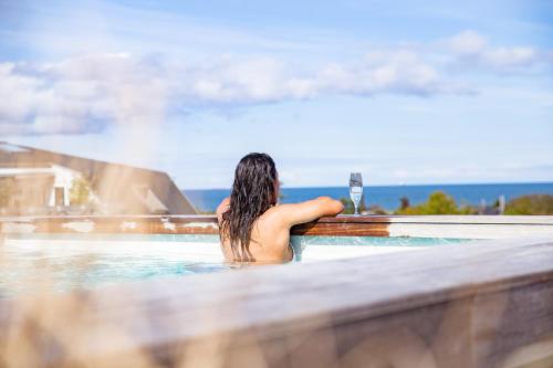 a woman in a swimming pool with a glass of wine at Hotel Viking Aqua Spa & Wellness in Sæby