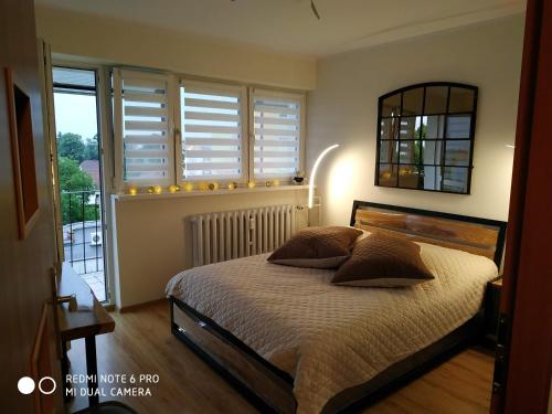 sypialnia z łóżkiem i oknem z okiennicami w obiekcie Apartament Briesen w mieście Wąbrzeźno