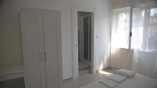 a white room with a bed and a window at Binario 2 in San Giorgio a Cremano
