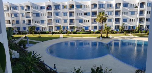 un gran edificio de apartamentos con una gran piscina en Alcudia Smir 3 chambres, en M'diq