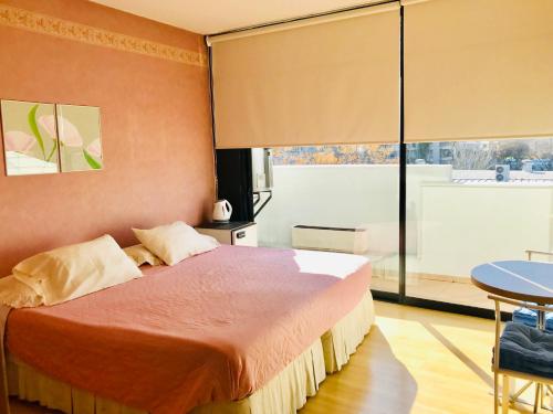 a bedroom with a bed and a large window at Regency Bombal Apartments in Mendoza