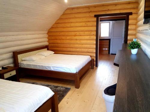 a bedroom with two beds in a log cabin at Casa de Greta in Svityazʼ