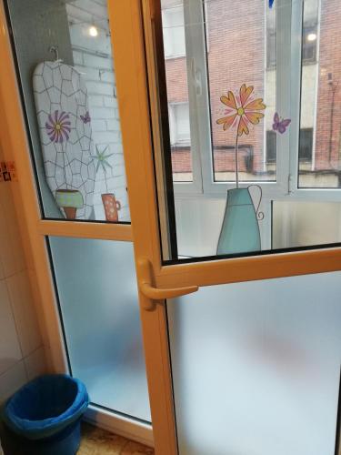 a window with a vase on it next to a door at Alojamiento Quintanilla in Gijón