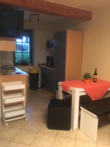 a kitchen with a table with a red cloth on it at Ferienappartements Anke Lange in Waren