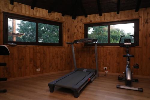a gym with a treadmill and a bike in a room at Agriturismo San Cataldo in Motta Camastra