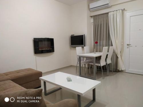 ein Wohnzimmer mit Sofa und Tisch in der Unterkunft LAVIM Apartments 2 in Sykia