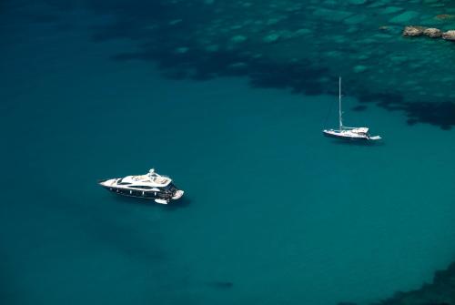 two boats are sitting in the water at Brand New Apartments - free parking in Sveti Stefan