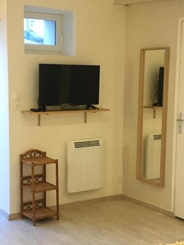 a living room with a flat screen tv on a wall at Les 3 échoppes in Chargé