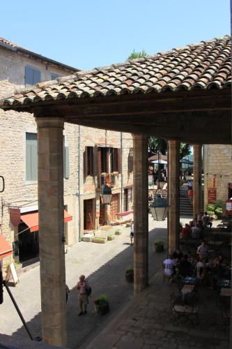 un groupe de personnes assises dans une cour d'un bâtiment dans l'établissement Chambre cozy et Salon de 60 m2 au coeur de la cité, à Cordes-sur-Ciel