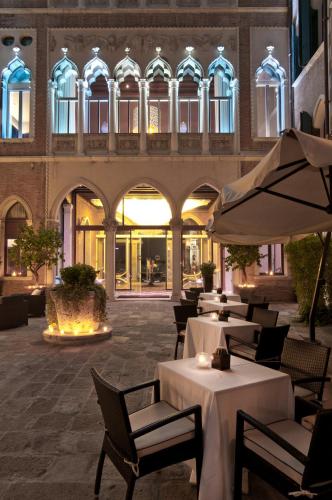a restaurant with tables and umbrellas in front of a building at Sina Centurion Palace in Venice