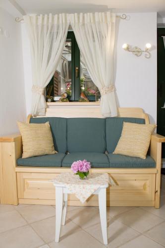 a living room with a blue couch and a table at House Corte dei Matte' in Rovinj