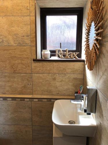a bathroom with a white sink and a window at Casa in Gateshead
