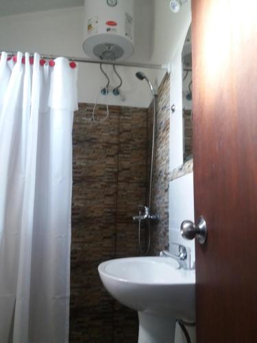 a bathroom with a sink and a shower curtain at Cabañas San Jorge in Termas del Daymán
