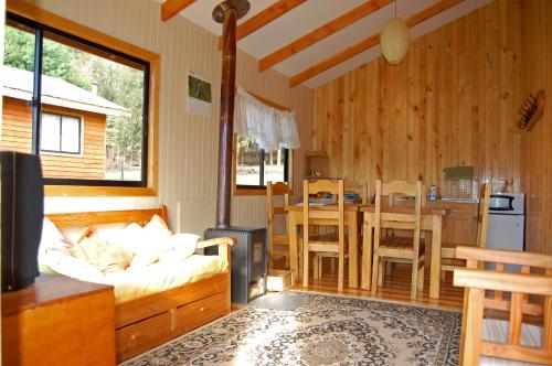 a living room with a couch and a kitchen at Parque Ilihue in Lago Ranco