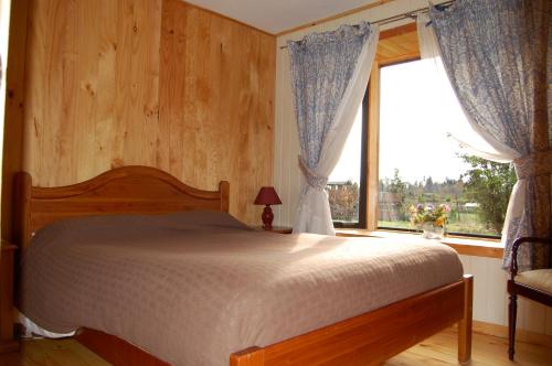 1 dormitorio con cama y ventana grande en Parque Ilihue, en Lago Ranco