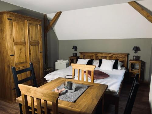 a bedroom with a bed and a wooden table and chairs at Willa Karkonoska in Karpacz