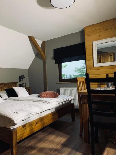 a bedroom with a bed and a desk and a window at Willa Karkonoska - klimatyczne pokoje i studia z ANEKSAMI KUCHENNYMI - Śniadania Sauna Grota Solna Siłownia Parking WI-FI W CENIE in Karpacz