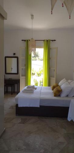 a bedroom with a bed with green curtains and a television at Mela Studios in Panormos Kalymnos