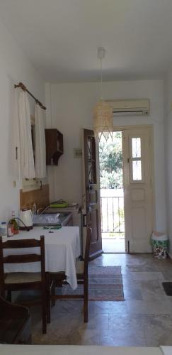 a room with a table and a kitchen with a door at Mela Studios in Panormos Kalymnos