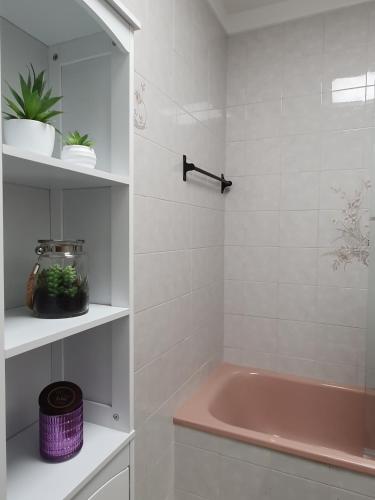a bathroom with a pink tub and a pink sink at Ninho Jardim do Morro in Vila Nova de Gaia