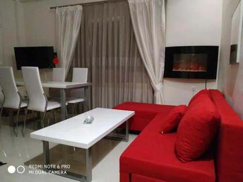 a living room with a red couch and a table at LAVIM Apartments in Sikia