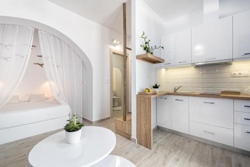 a kitchen with white cabinets and a white table at Blue Paradise in Ierápetra