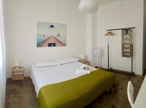 una camera da letto con un grande letto bianco con una coperta verde di Casa da Ilaria a Sottomarina