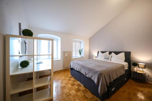 a bedroom with a large bed and two windows at Stomorica Apartments in Zadar