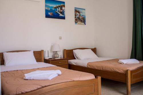 a room with two beds with towels on them at Sun & Sea in Mochlos