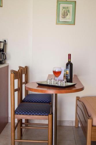 a table with two glasses of wine and a bottle at Sun & Sea in Mochlos