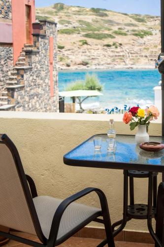 a table with flowers on it with a view of the ocean at Sun & Sea in Mochlos