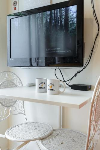 a flat screen tv sitting on top of a table at Charming Boutique Studio - TLv Center in Tel Aviv