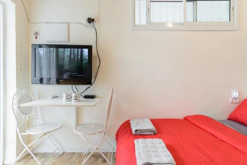 a bedroom with a bed and a table and a tv at Charming Boutique Studio - TLv Center in Tel Aviv