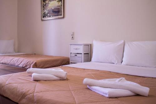 two beds with towels on them in a room at Sun & Sea in Mochlos