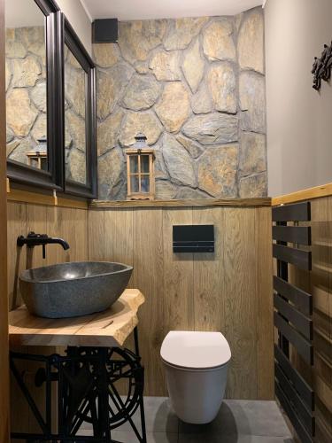 a bathroom with a sink and a stone wall at Willa Karkonoska - klimatyczne pokoje i studia z ANEKSAMI KUCHENNYMI - Śniadania Sauna Grota Solna Siłownia Parking WI-FI W CENIE in Karpacz