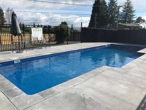 a swimming pool with blue water in a yard at Rotorua Thermal Holiday Park in Rotorua