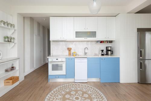 a kitchen with white cabinets and blue appliances at Akti Elia Villas Beachfront Chalkidiki in Elia