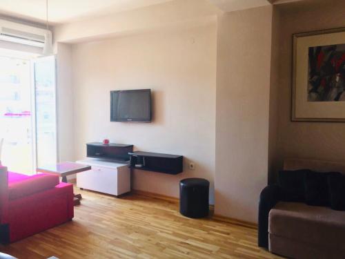 Una sala de estar con un sofá y un televisor en la pared. en Baron Ohrid Makedonija, en Ohrid