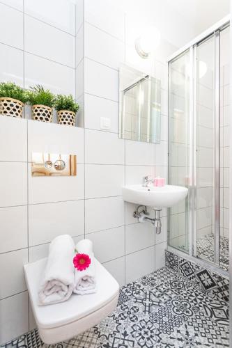 a white bathroom with a sink and a toilet at Arenda in Karwia