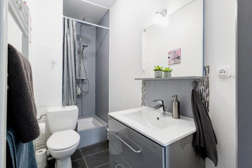 a bathroom with a white sink and a toilet at Comfort Stay Basel Airport 1B46 in Saint-Louis