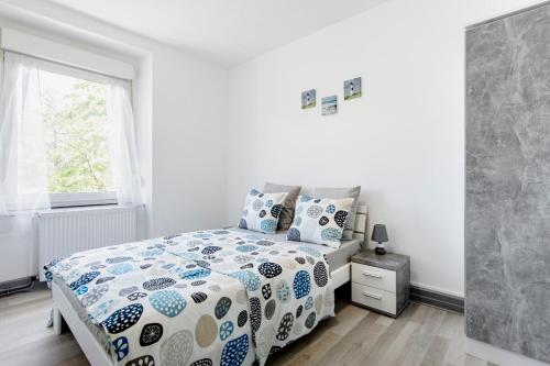 Schlafzimmer mit einem Bett mit einer blauen und weißen Bettdecke in der Unterkunft Comfort Stay Basel Airport 1B46 in Saint-Louis