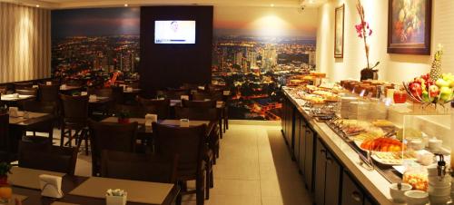 a restaurant with a breakfast bar with a view of a city at Hotel D'Luca in Cuiabá