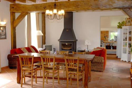 une salle à manger avec une table et une cheminée dans l'établissement Domaine de la Gaucherie, à Langon