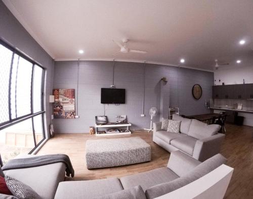 a living room with a couch and a tv at Bunk Inn Hostel in Bundaberg